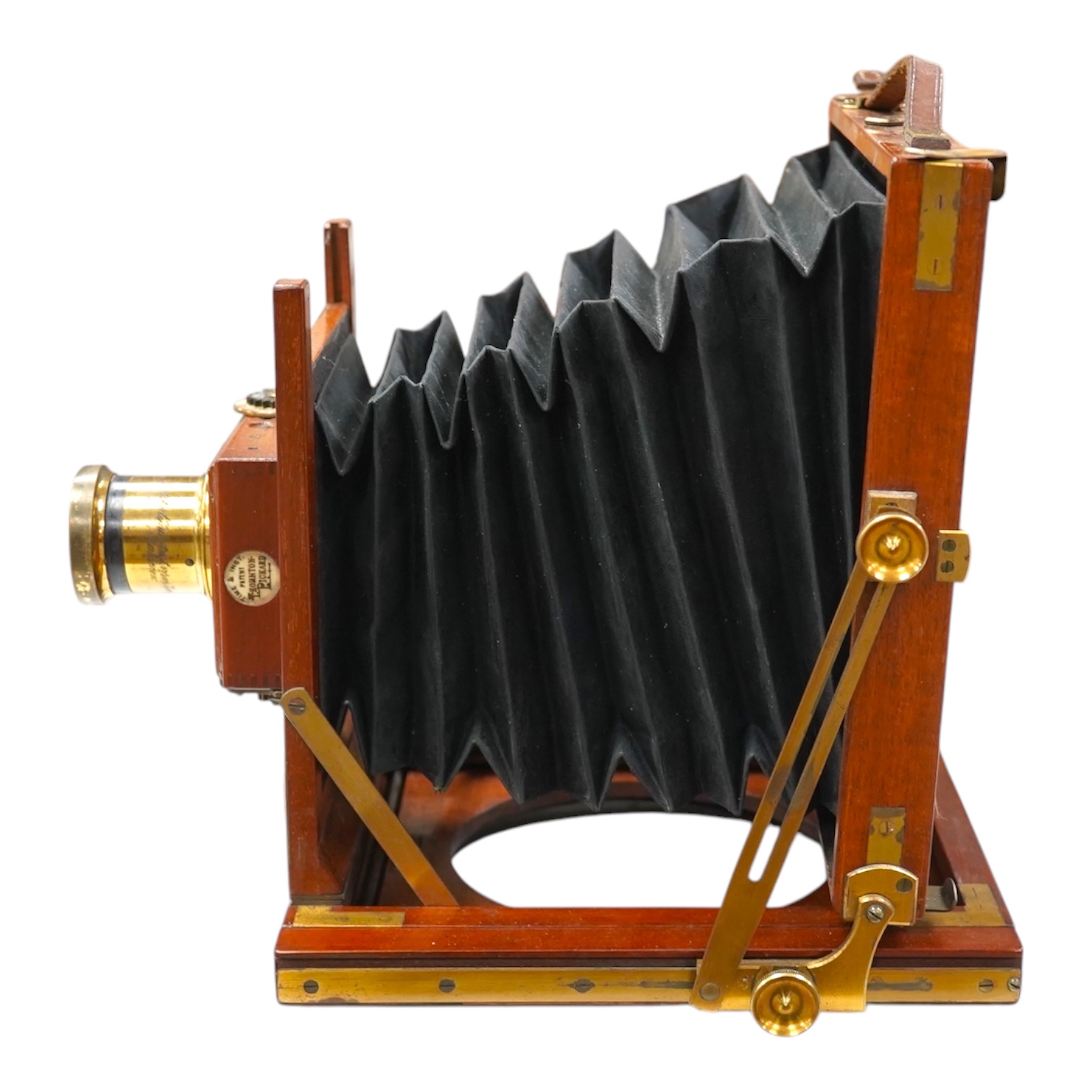 A late 19th/early 20th century brass and mahogany half plate bellows camera with a lens and a shutter action by Thornton Pickard. Condition - glass missing